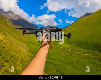 Hellhäutiger Erwachsener mit Drohne in sonniger Berglandschaft Stockfoto