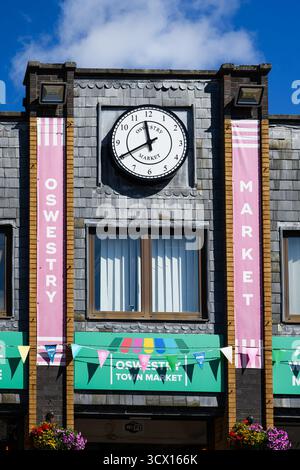 Oswestry, England, Großbritannien - 29. August 2025; Schilder und Uhr auf dem Powis Hall Indoor Market außen Stockfoto