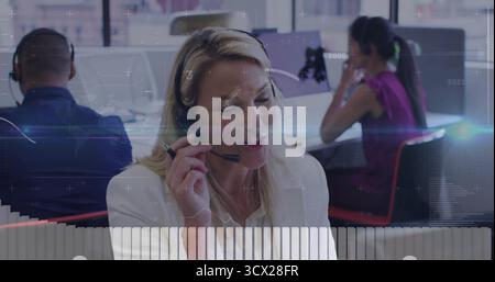 Kundendienstmitarbeiter mit Headset, der Anrufe im Büro mit Monitoren und Trennwänden abwickelt Stockfoto