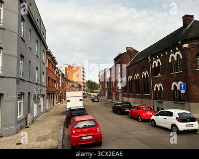 Lüttich, Belgien - 20. Oktober 2023: Blick auf die belgische Straße in Lüttich mit roten Autos, Backsteinhäusern und einer ruhigen Wohnatmosphäre. Stockfoto