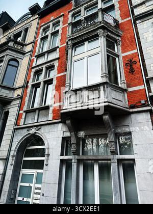 Lüttich, Belgien - 20. Oktober 2023: Historisches belgisches Gebäude mit roter Backsteinfassade, Steindetails und einem markanten Erkerfenster. Stockfoto