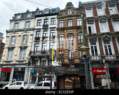 Lüttich, Belgien - 20. Oktober 2023: Bunte Straßenszene in Lüttich mit historischen Gebäuden, Geschäften und einer Pizzeria in Grano. Stockfoto