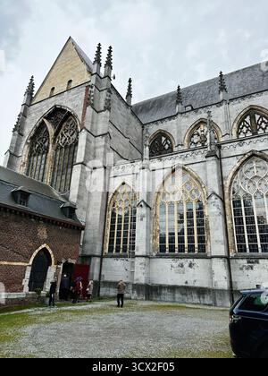 Lüttich, Belgien - 20. Oktober 2023: Besucher nähern sich einer historischen belgischen Kirche in Lüttich und bewundern mittelalterliche Steinarchitektur und hohe Bogenfenster Stockfoto