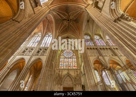 Innenraum der Auxerre Kathedrale mit Lichtfilterung durch bunte Buntglasfenster und kunstvoll verzierte Gewölbe Stockfoto