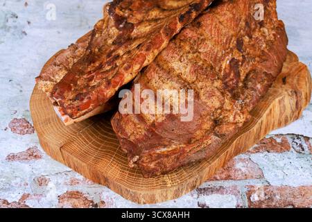 Saftiges Barbecue saftige geräucherte Schweinerippchen, perfekt auf Holzbrett platziert Stockfoto