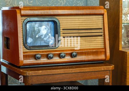 Vintage-Fernseher aus Holz mit kleinem Monitor auf Holztisch im Retro-Wohnzimmer Stockfoto