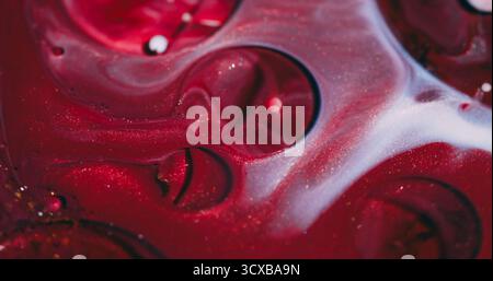 Tintenblasen. Ölstruktur. Defokussierte rote lila weiße Farbe Acryl Flüssigkeit Glitzer Runde Strömung schwebend auf abstraktem lebendigen Hintergrund. Stockfoto