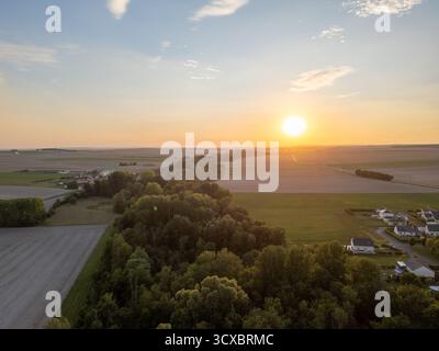 Bergnicourt, Rethel, Ardennes, Grand-Est, Frankreich, am 28. August 2025 erleuchtet Ein atemberaubender Sonnenuntergang die weiten Felder und eine dichte Baumlinie am Horizont während der Abenddämmerung Stockfoto