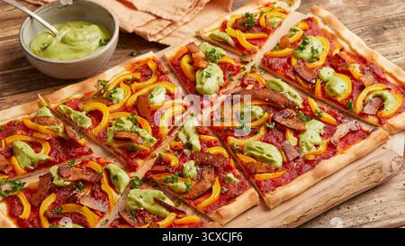 Pizza mit Kokosspeck und Avocado Stockfoto
