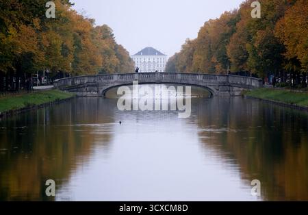 München, Deutschland. Oktober 2025. Am Nymphenburger Kanal stehen herbstliche Bäume. Das Schloss Nymphenburg ist im Hintergrund zu sehen. Quelle: Sven Hoppe/dpa/Alamy Live News Stockfoto