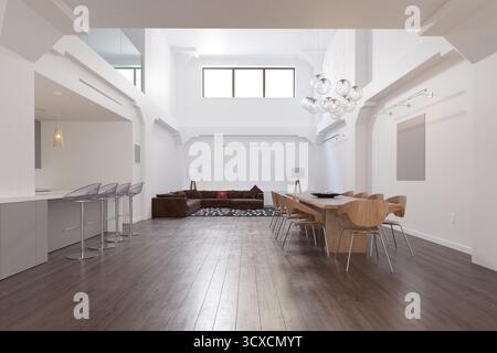 Ein geräumiges, modernes, offenes Loft-Apartment mit hohen Decken, einem Essbereich und einem Wohnzimmer. Stockfoto