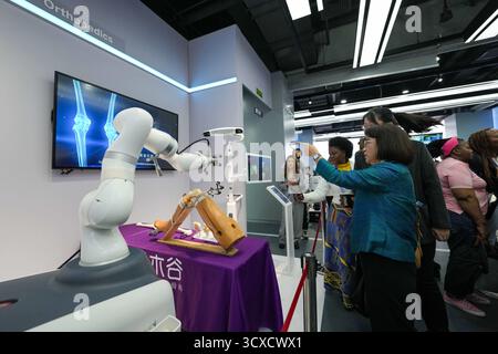 Peking, China. Oktober 2025. Vertreter, die zum Global Leaders' Meeting on Women in Peking sind, erfahren mehr über einen KI-gestützten orthopädischen Roboter in der Beijing World of Robots in Peking, der Hauptstadt Chinas, 14. Oktober 2025. Quelle: Xue Yuge/Xinhua/Alamy Live News Stockfoto