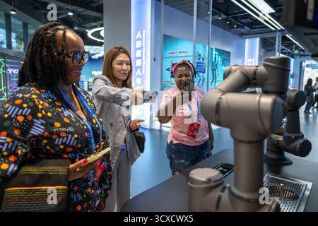 Peking, China. Oktober 2025. Vertreter, die zum Global Leaders' Meeting on Women in Peking sind, sehen sich einen Roboter beim Kaffeebrühen in der Beijing World of Robots in Peking, der Hauptstadt Chinas, am 14. Oktober 2025 an. Quelle: Du Zixuan/Xinhua/Alamy Live News Stockfoto