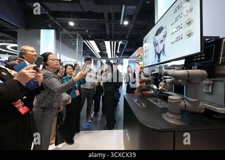 Peking, China. Oktober 2025. Vertreter, die zum Global Leaders' Meeting on Women in Peking sind, sehen sich am 14. Oktober 2025 die Demonstration eines robotischen Baristas in der Beijing World of Robots in Peking, der Hauptstadt Chinas, an. Quelle: Xue Yuge/Xinhua/Alamy Live News Stockfoto