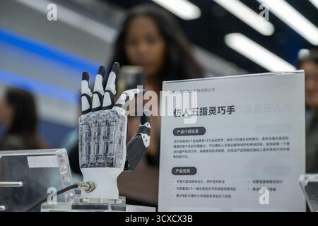 Peking, China. Oktober 2025. Vertreter, die zum Global Leaders' Meeting on Women in Peking sind, erfahren mehr über eine Roboterhand bei der Beijing World of Robots in Peking, der Hauptstadt Chinas, 14. Oktober 2025. Quelle: Du Zixuan/Xinhua/Alamy Live News Stockfoto