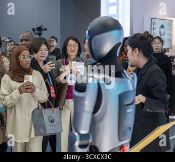 Peking, China. Oktober 2025. Vertreter, die zum Global Leaders' Meeting on Women in Peking sind, erfahren mehr über einen humanoiden Roboter in der Beijing World of Robots in Peking, der Hauptstadt Chinas, am 14. Oktober 2025. Quelle: Du Zixuan/Xinhua/Alamy Live News Stockfoto