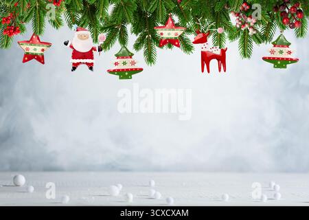 Weihnachtsmann und Ornamente hängen an der Girlande über der Schneeszene Stockfoto