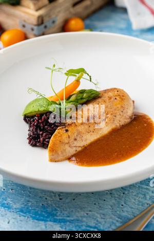 Gegrilltes Hähnchenfilet mit schwarzem Reis und Gemüse in Sauce Stockfoto