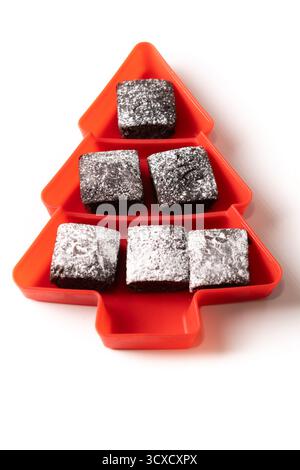 Schokoladen-Brownies mit Puderzucker in der Tannenschale isoliert auf weißem Hintergrund Stockfoto