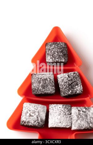 Schokoladen-Brownies mit Puderzucker in der Tannenschale isoliert auf weißem Hintergrund Stockfoto