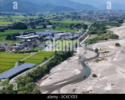 Eine Stadt mit einem Fluss, der durch sie fließt. Der Fluss ist von einem Sandgebiet umgeben. Die Stadt ist voller Häuser und Gebäude Stockfoto