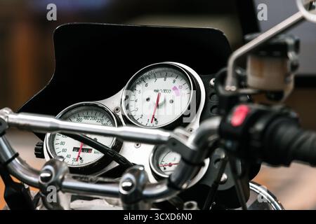 Eine detaillierte Nahaufnahme eines Motorradcockpits mit Tachometer- und Drehzahlmesseranzeigen auf einem glänzenden Chromlenker. Perfekt für Automobile Stockfoto