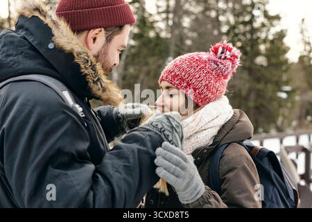 Seitenansicht von Mann und Frau in Outwear, die zusammen wandern und einander lieben Stockfoto