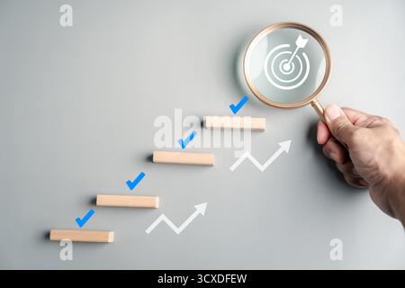 Planung und Ausführung mit Holzblöcken als Stufen, Häkchen, Lupe mit Stockfoto