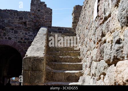 Alte Steintreppe in einer historischen Festung mit blauem Himmel. Stockfoto