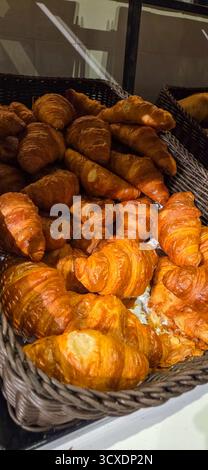 Ein Korb gefüllt mit frisch gebackenen Croissants in einer Bäckerei. Stockfoto