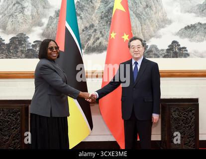 Peking, China. Oktober 2025. Der chinesische Vize-Premierminister Ding Xuexiang, auch Mitglied des Ständigen Ausschusses des Politbüros des Zentralkomitees der Kommunistischen Partei Chinas, trifft sich mit der Ministerpräsidentin Mosambiks Maria Benvinda Delfina Levi, die am 14. Oktober 2025 in Peking zum Global Leaders' Meeting on Women ist. Quelle: Ding Haitao/Xinhua/Alamy Live News Stockfoto