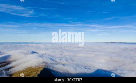 Berggipfel tauchen während einer atemberaubenden Wolkenumkehr aus einem Wolkenmeer auf Stockfoto