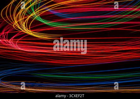 Bunte, wirbelnde Lichtstreifen auf schwarzem Hintergrund Stockfoto