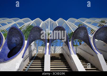 Die beeindruckende Architektur des Umbracle in Valencia, Spanien, mit Einer Treppe, die nach oben führt zwischen weißen Säulen, die mit blauen Mosaikbögen verziert sind. Stockfoto