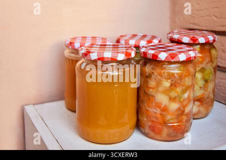 Hausgemachte Obst- und Gemüsekonserven in rustikalen Gläsern Stockfoto