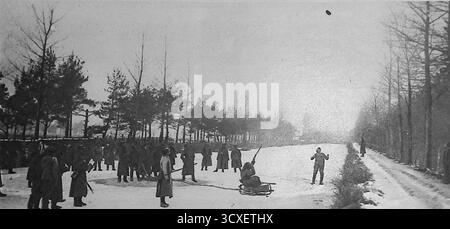Aus Le Miroir, 4. März 1917, zeigt russische Soldaten in Frankreich, die ein Schlittenspiel üben. Ein Soldat, der auf einem Schlitten sitzt, fährt einen Eiskanal hinunter, während er versucht, auf Kappen zu schießen, die in die Luft geworfen werden. Andere Truppen säumen die gefrorenen Banken, um den Wettbewerb zu beobachten. Dieses Foto veranschaulicht sowohl den Einfallsreichtum der Soldaten bei der Schaffung von Ablenkungen als auch die Mischung militärischer Fähigkeiten mit Spielen während des langen Winters des Ersten Weltkriegs Stockfoto