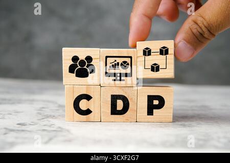 Holzwürfel, die die Abkürzung CDP mit Symbolen für Personen, Analysen und Datennetzwerke bilden. Konzept der Kundendatenplattform, Marketingtechnologie, Stockfoto