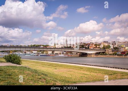 Die Brücke über die Donau in Belgrad, Serbien. Kreuzfahrtschiffe liegen am Ufer vor. Stockfoto