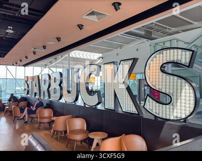 London, England, Großbritannien - 20. Mai 2025: Starbucks Coffee Shop in einem der Satellitenterminals des Terminals 5 am Flughafen London Heathrow Stockfoto