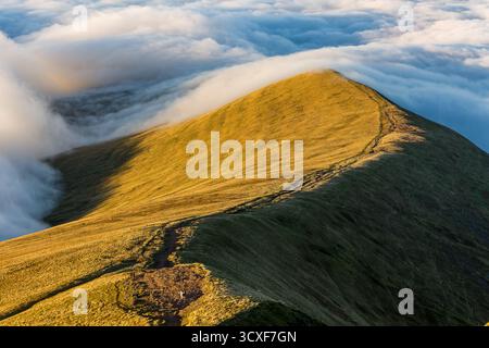 Atemberaubende Temperaturumkehr über einem goldenen Bergrücken in Brecon Beacons, Wales Stockfoto