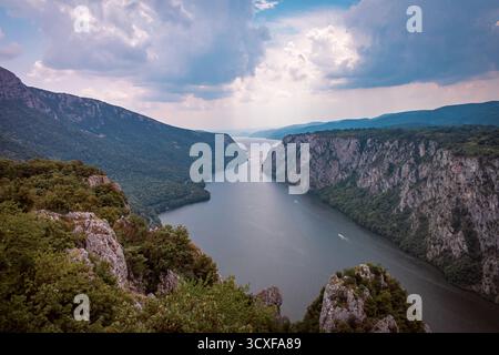 Die Donau fließt entlang der Grenze zwischen Serbien und Rumänien. Eine atemberaubende Landschaft mit Bergen und felsigen Klippen, bedeckt mit Wäldern und Moos. Stockfoto