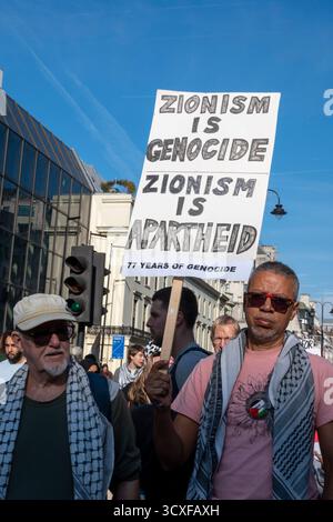 Nationale Demonstration für Palästina, London. Demonstranten mit dem Zeichen "Zionismus ist Völkermord, Zionismus ist Apartheid". Stockfoto