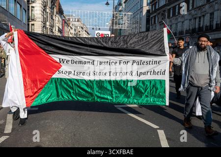 Nationale Demonstration für Palästina, London. Demonstranten tragen eine große palästinensische Flagge mit der Aufschrift " Wir fordern Gerechtigkeit für Palästina, stoppen den Staatsterror" Stockfoto