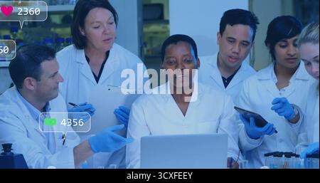 Laborbeschichteter afroamerikanischer Wissenschaftler mit blauen Handschuhen am Labortisch, mit Laptop-Tablett-Zwischenablage Stockfoto