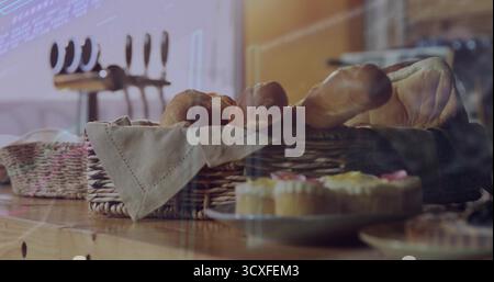 In der Bäckerei wird ein Korbkorb mit Brotlaiben und Baguettes sowie gefrorene Cupcakes präsentiert Stockfoto