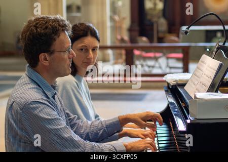 Emma Abbate und Julian Perkins treten in der St Michael's Church Framlingham ein Nachmittagskonzert mit Klavierduetten auf einem Flügel auf Stockfoto