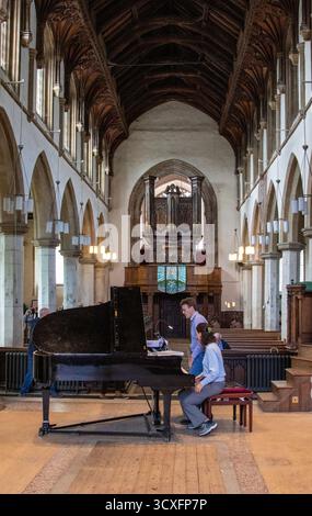 Emma Abbate und Julian Perkins treten in der St Michael's Church Framlingham ein Nachmittagskonzert mit Klavierduetten auf einem Flügel auf Stockfoto