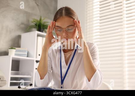 Müde Krankenschwester am Tisch in der Klinik, Tiefwinkelblick Stockfoto