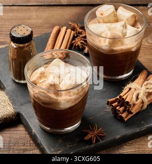 Zwei Gläser heiße Schokolade mit flauschigen Marshmallows auf einem Schieferbrett. Eine Nahaufnahme des Wintergetränks Stockfoto