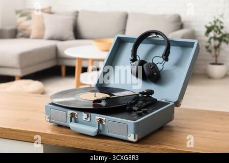 Stilvolles Wohnzimmer mit Plattenspieler und Kopfhörern auf Kommode Stockfoto